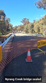 A road with a detour sign and a traffic cone

Description automatically generated