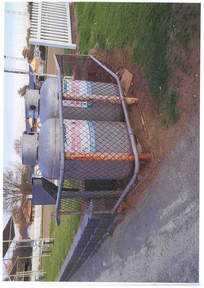 Large containers in a fenced area

Description automatically generated
