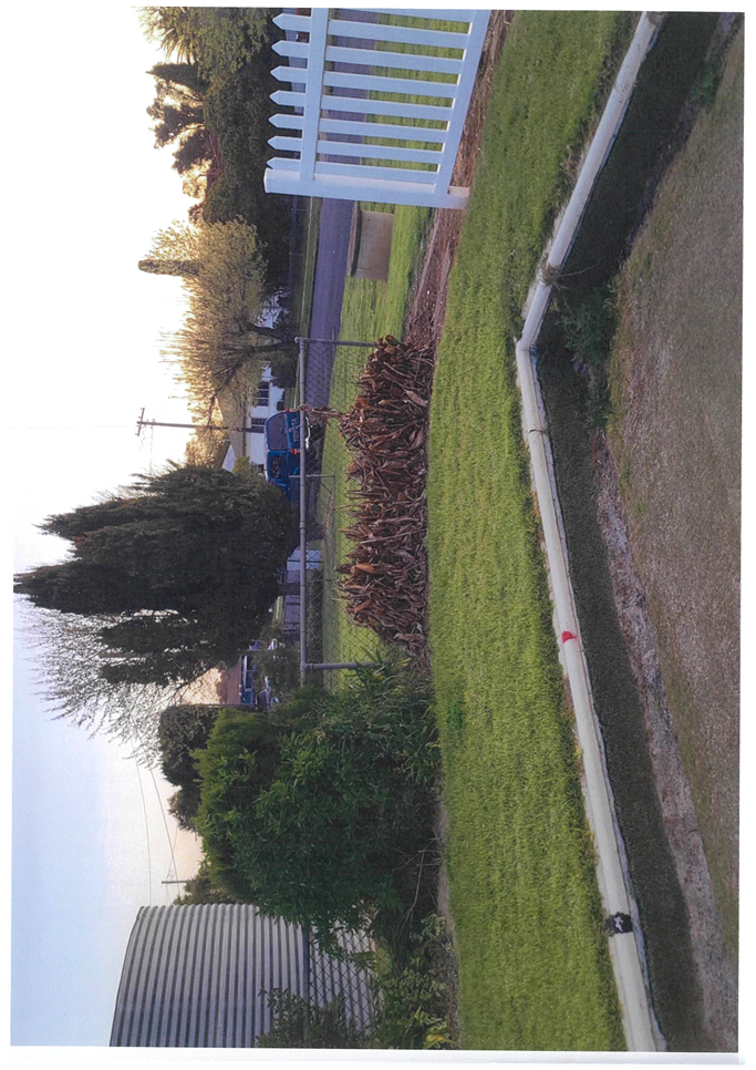 A lawn with a sign and trees

Description automatically generated with medium confidence